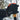 Black glove with orange accents holding a tool, with 'HEAT UP' branding, against a blurred natural background.