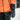 Person wearing an orange jacket and black heated gloves in a snowy setting