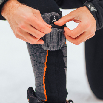 Opening the battery pocket on the cuff of Heat Up Merino Wool+ heated socks