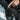 Finger pressing the heat button on the cuff of a Heat Up Mountain heated mitten in the snow