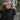 Woman in a knit hat opening her jacket to show the Heat Up women's heated vest underneath, heat button lit